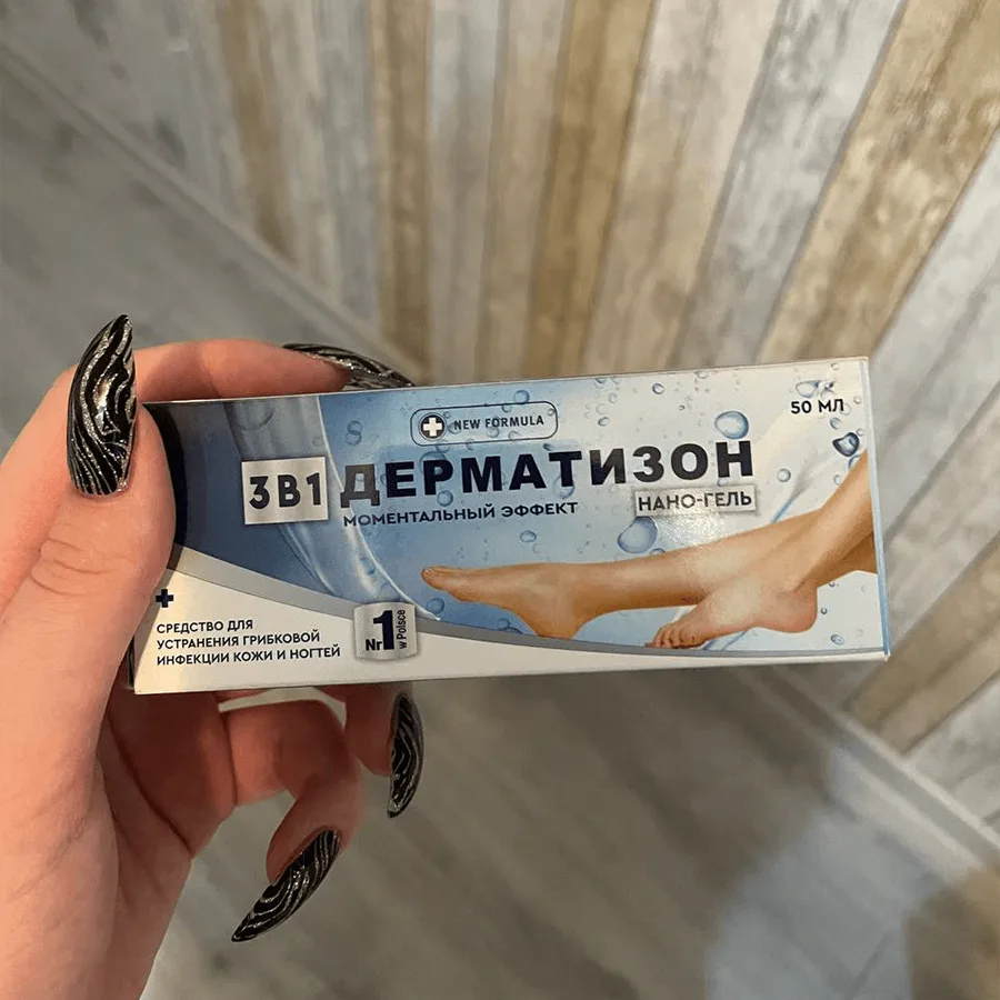 Женская рука держит картонную упаковку с кремом-гелем Дерматизон