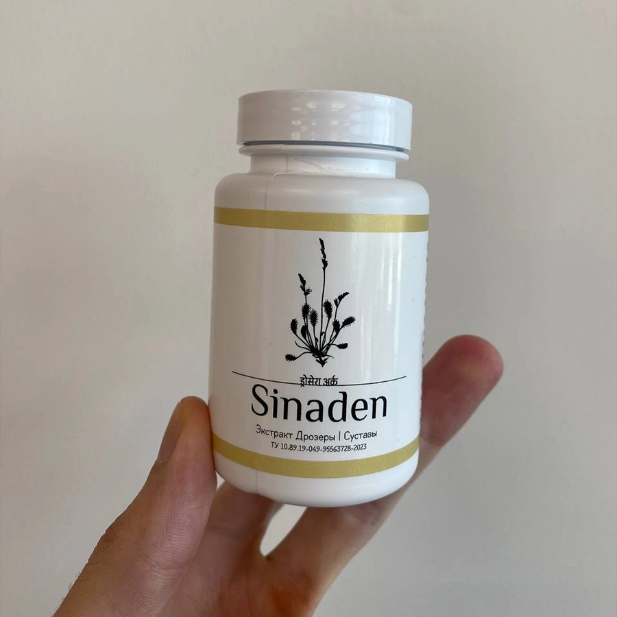 Рука держит белую пластиковую баночку с капсулами Синаден