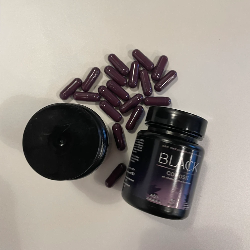 Две баночки Black Cohosh на столе и рассыпанные капсулы