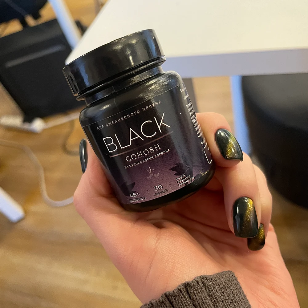 Женская рука держит баночку Black Cohosh