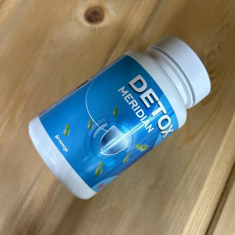 Баночка с капсулами Детокс Меридиан оежит на столе лицевой стороной вверх