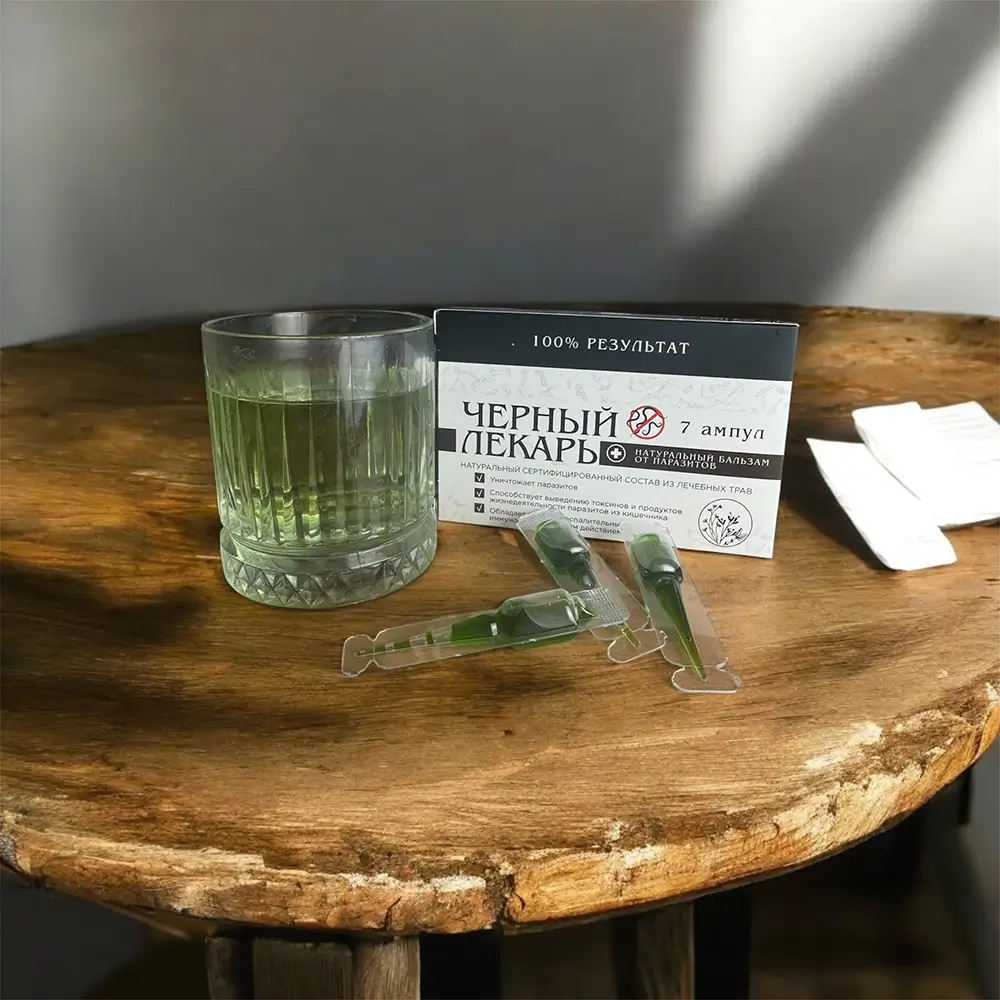 Разведенный раствор Чёрный Лекарь в стакане воды с упаковкой и ампулами для приема против гельминтов